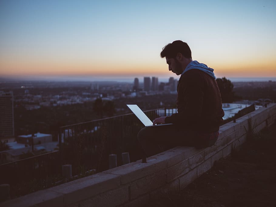 Person using a laptop alone at night, illuminated by screen light